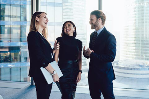 zwei frauen, ein mann, die sich unterhalten, sie sind in business kleidung
