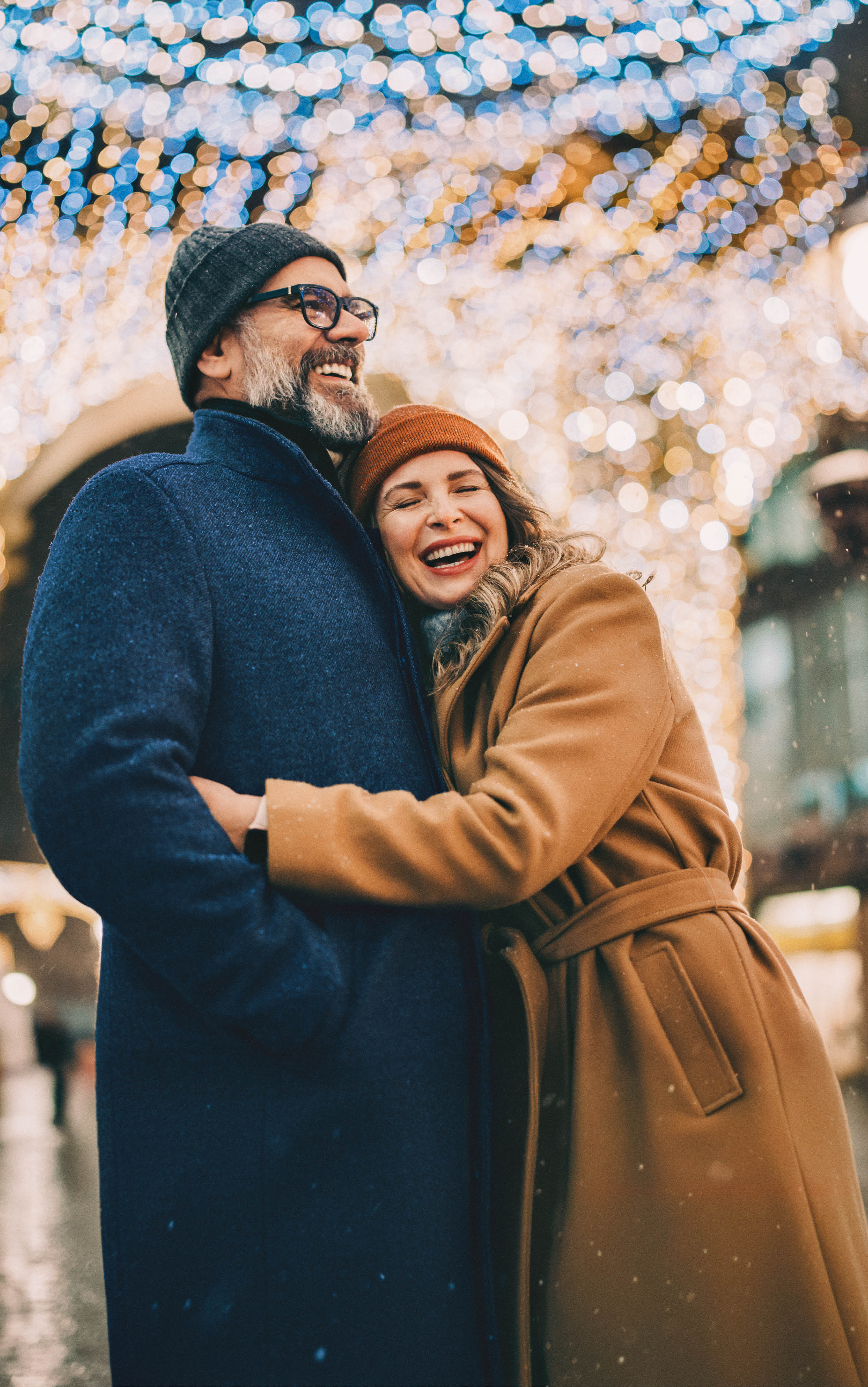 Eine lachende Frau umarmt einen Mann, der auch lächelt
